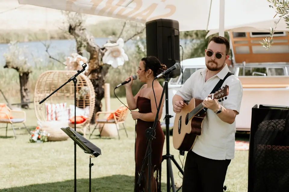 A Margarida a cantar e o João à guitarra num cocktail ao ar livre