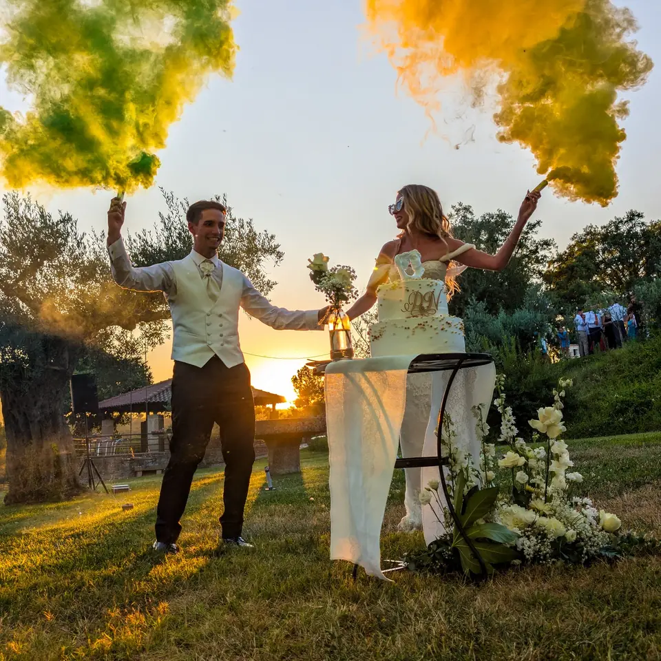 Noivos ao pôr do sol com fumo amarelo e verde
